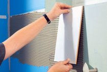 Laying tiles on a plasterboard wall in a bathroom