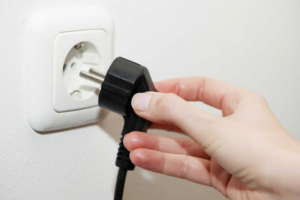 female hand inserts the plug into the socket