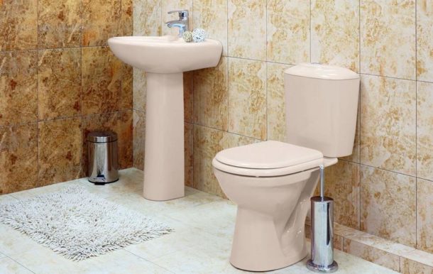 Beige toilet bowl on the background of porcelain stoneware of a suitable color